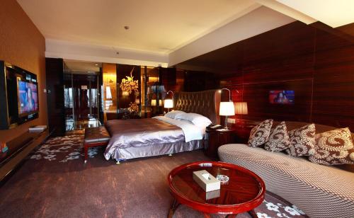 um quarto de hotel com uma cama e um sofá em Hotel Fortune em Shunde