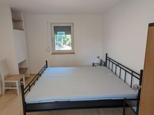 ein großes Bett in einem Zimmer mit Fenster in der Unterkunft Holiday home Werder Havel in Werder
