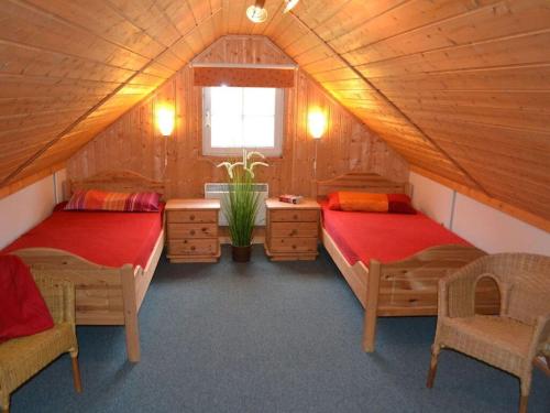 a room with two beds in a wooden house at Holiday home Vogelsang in Userin
