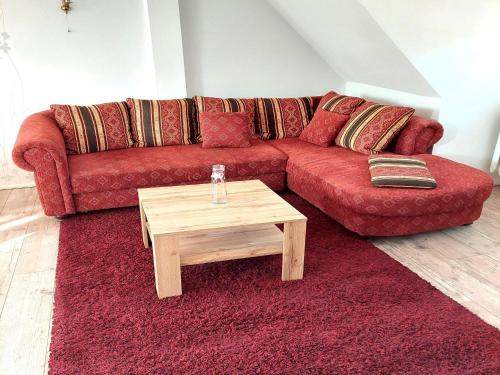 a living room with a red couch and a coffee table at Holiday Home in idyllic Ziesar near the Natuurpark in Gladau