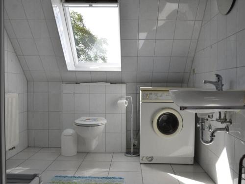 uma casa de banho com uma máquina de lavar roupa e um lavatório em Holiday apartment nature view em Conow