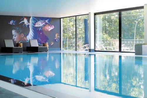 a swimming pool in a building with a painting on the wall at Holiday home in Drewitz with a shared pool in Drewitz