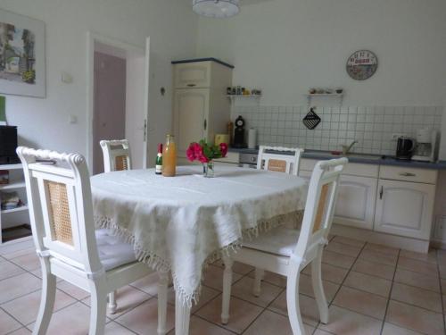 uma cozinha com uma mesa e cadeiras com uma toalha de mesa branca em Holiday house by the lake em Fürstenwerder