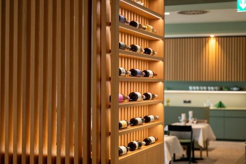 a wall with bottles of wine in a restaurant at Erikson Hotel in Sindelfingen
