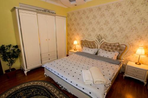 a bedroom with a white bed with two lamps at District One Villa with Private Courtyard and Terrace in Bucharest