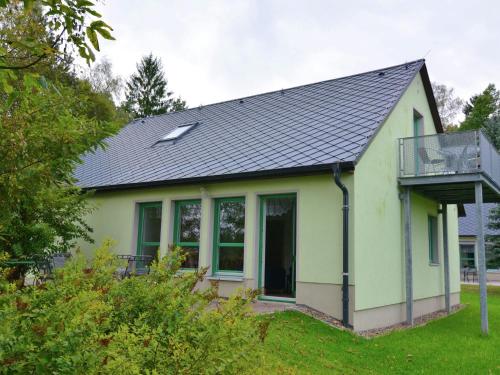 une petite maison verte avec un toit noir dans l'établissement House full of charm with garden 10min from the Pointe du Raz, à Cléden-Cap-Sizun