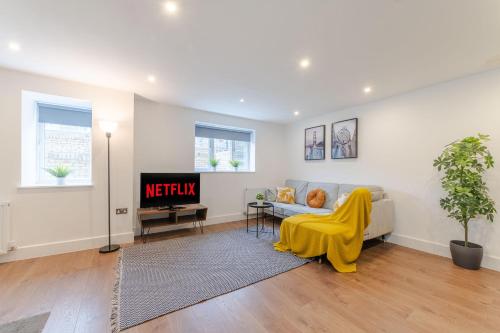ein Wohnzimmer mit einem Sofa und einem TV in der Unterkunft Luxury 2 Bedroom London Home - Vauxhall & Battersea in London