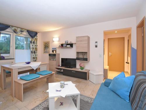 sala de estar con sofá azul y mesa en Roomy Apartment in Lichtenhain with Pond, en Lichtenhain