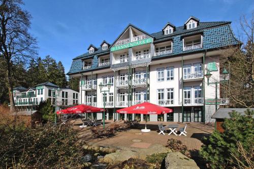 um grande edifício com guarda-chuvas vermelhos em frente em Apartment in fir with a balcony or a terrace em Tanne