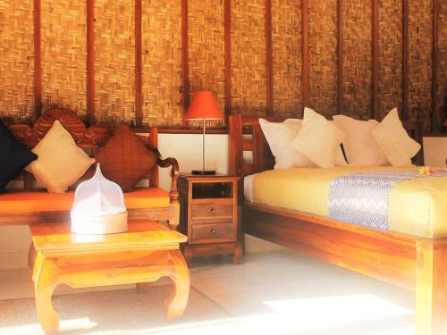 a bedroom with two beds and a table with a lamp at Coco Resort Penida in Nusa Penida