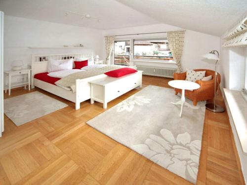 um quarto com uma cama branca e almofadas vermelhas em Sunshine Apartment Anne em Garmisch-Partenkirchen