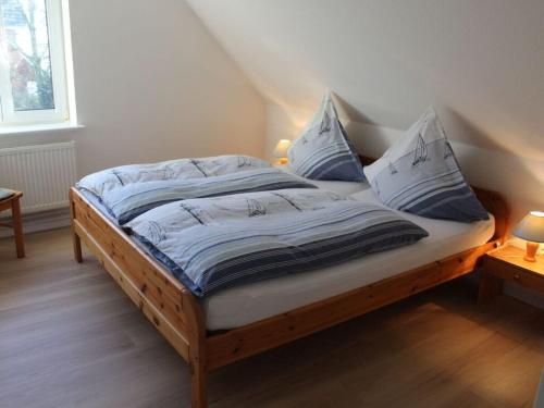 uma cama com lençóis e almofadas azuis e brancos em Holiday apartment in the marsh 2 em Ockholm