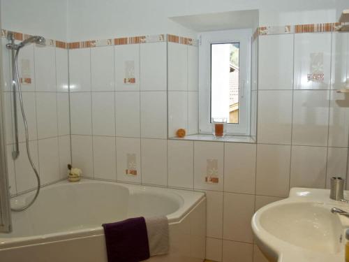 a white bathroom with a tub and a sink at Holiday apartment Diana in Oberstaufen