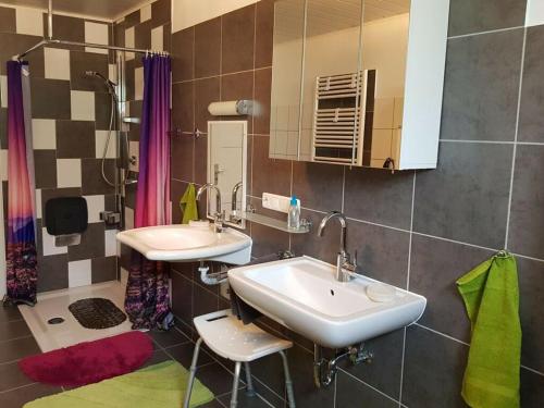 Apartment in Olsberg في Ehrenberg: حمام مغسلتين ومرآة