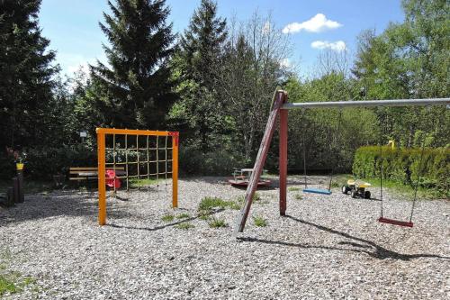 einen Spielplatz mit Schaukel in einem Park in der Unterkunft Tennenbronn Holiday Park Tennenbronn in Tennenbronn