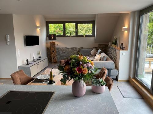 ein Wohnzimmer mit einer Blumenvase auf dem Tisch in der Unterkunft Well equipped apartment in Monschau near bus stop in Mützenich