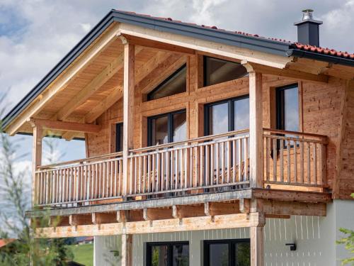 a log home with a wrap around deck at Inzell Chalets with private pool in Inzell