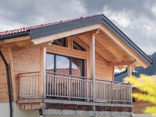ein Haus mit einem Balkon mit schwarzem Dach in der Unterkunft Inzell Chalets with private pool in Inzell