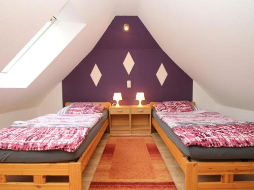 2 Betten in einem Zimmer mit Dachgeschoss in der Unterkunft Holiday House Ganesha, Utarp in Utarp