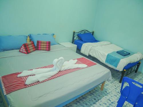 a room with two beds with towels on them at Noot's Bar And Guesthouse in Kanchanaburi City