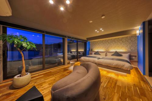 a large bedroom with two beds and a couch at SAZANAMI LAKE FRONT in Fujikawaguchiko
