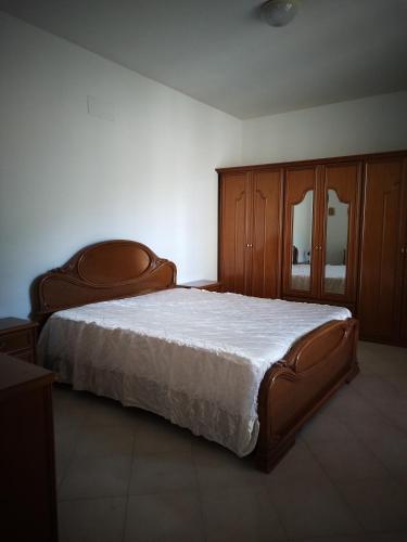 - une chambre avec un grand lit et des placards en bois dans l'établissement 1900, à Olevano sul Tusciano