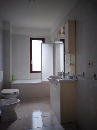 uma casa de banho com um WC, um lavatório e uma banheira em 1900 em Olevano sul Tusciano