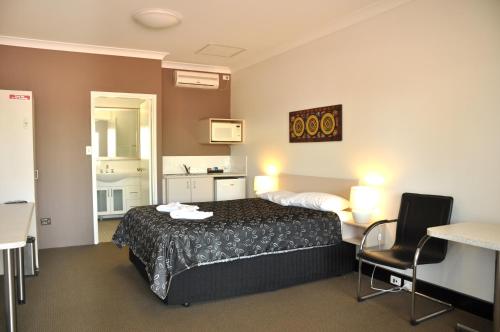 a hotel room with a bed and a table and chairs at Pinjarra Resort in Pinjarra