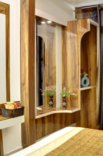 a bedroom with a wooden cabinet with two plants in it at Hotel Star Villa - Front of New Delhi Railway Station & 5 Minute from Connaught Place in New Delhi