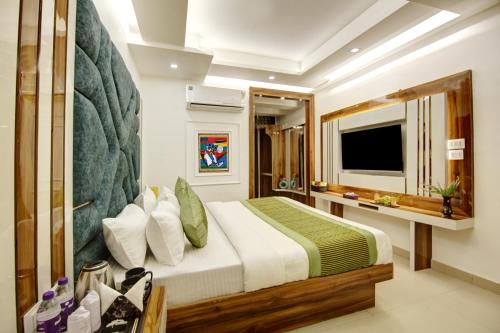 een slaapkamer met een groot bed en een televisie bij Hotel Star Villa - Front of New Delhi Railway Station in New Delhi