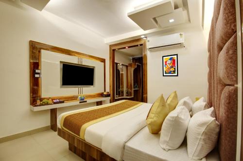 a bedroom with a bed with a tv on the wall at Hotel Star Villa - Front of New Delhi Railway Station & 5 Minute from Connaught Place in New Delhi