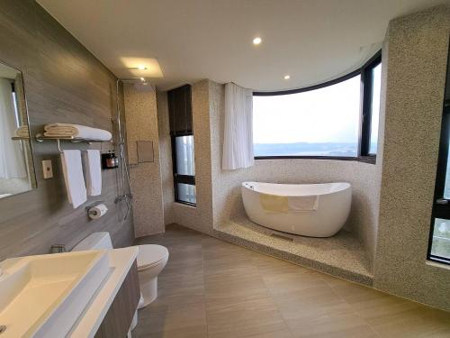 baño con bañera grande y ventana en 森森‧沐旅, en Daxi