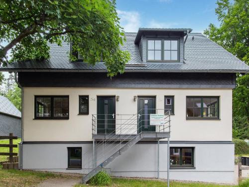 a house with a staircase in front of it at Spacious semi detached house with wood stove located directly on the Rennsteig in Eisfeld