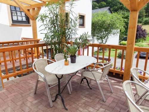 a patio with a table and chairs on a deck at A modern apartment in the Hunsr ck region s romantic Drohn Valley in Merschbach