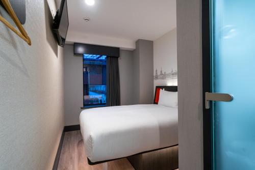 a hotel room with a bed and a window at easyHotel Oxford in Oxford
