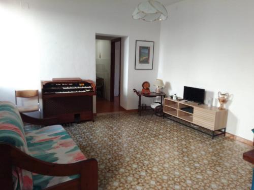 a living room with a piano and a couch at casa vacanza Sulmona centro in Sulmona