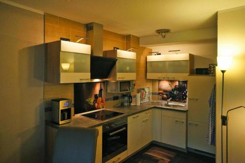 a kitchen with stainless steel appliances and wooden cabinets at Am Weberfeld Bodenmais in Bodenmais