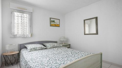 une chambre blanche avec un lit et une fenêtre dans l'établissement Perles du soleil - 01- Appt 4 pers, au Cap d'Agde