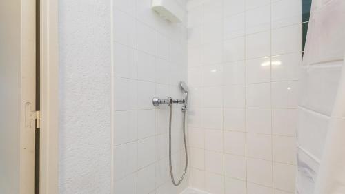 une salle de bain avec douche carrelée de blanc dans l'établissement Perles du soleil - 01- Appt 4 pers, au Cap d'Agde