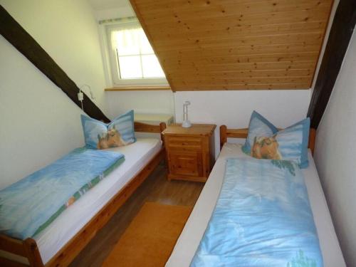 2 camas individuais num pequeno quarto com uma janela. em Holiday apartment Luxhof em Sankt Märgen