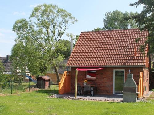 a small brick house with a table in front of it at Lovely Holiday Home in Zierow with Terrace in Zierow
