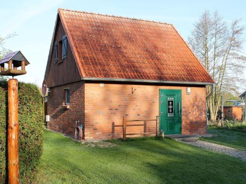 a red brick barn with a green door at Lovely Holiday Home in Zierow with Terrace in Zierow