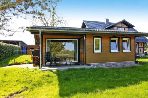 a tiny house with a patio and a table at Holiday home lake view Zemitz in Zemitz