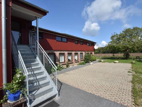 um edifício vermelho com uma escada ao lado de um pátio em Exquisite Mansion in Pugholz near Sea em Hasselberg