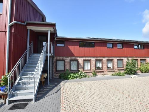 a red building with a staircase next to it at Exquisite Mansion in Pugholz near Sea in Hasselberg