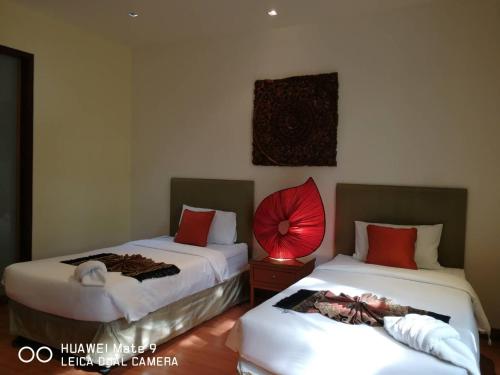 a room with two beds and a red fan on the wall at Hua Hin Blue Lagoon in Cha Am