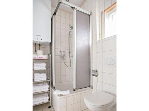 a white bathroom with a shower and a toilet at Appealing apartment in Motten in Motten