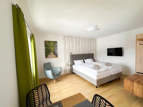 1 dormitorio con 1 cama, mesa y sillas en Holly GmbH Ferienwohnungen, en Bad Alexandersbad