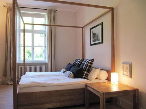 1 cama con marco de madera en una habitación en Gutshaus Zicker in Garz, en Garz