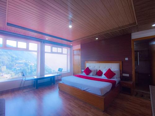 a bedroom with a large bed and a large window at Hotel Snow Ark inn, Dalhousie in Dalhousie